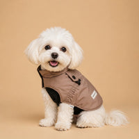 The Waterproof Puppy Jacket on a small white dog in a taupe jacket